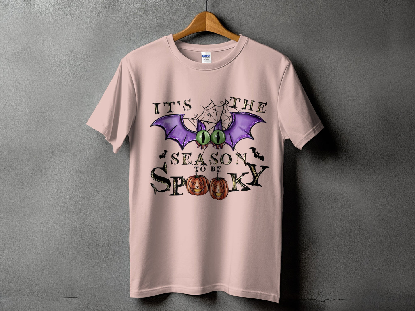 Pink t-shirt with "IT'S THE SEASON TO BE SPOOKY" Halloween graphic.