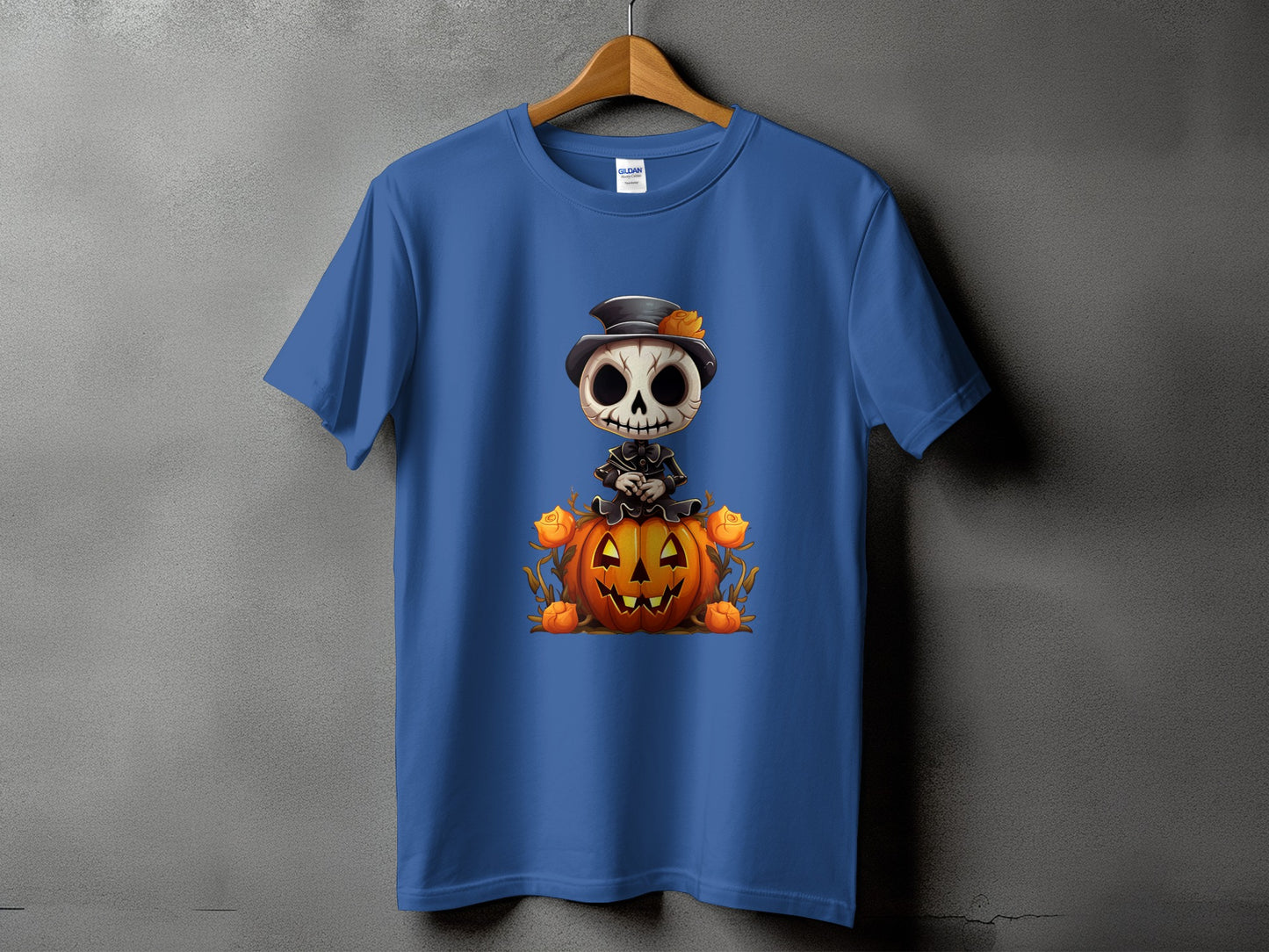 Blue t-shirt featuring a skeleton in a top hat sitting on a jack-o'-lantern.