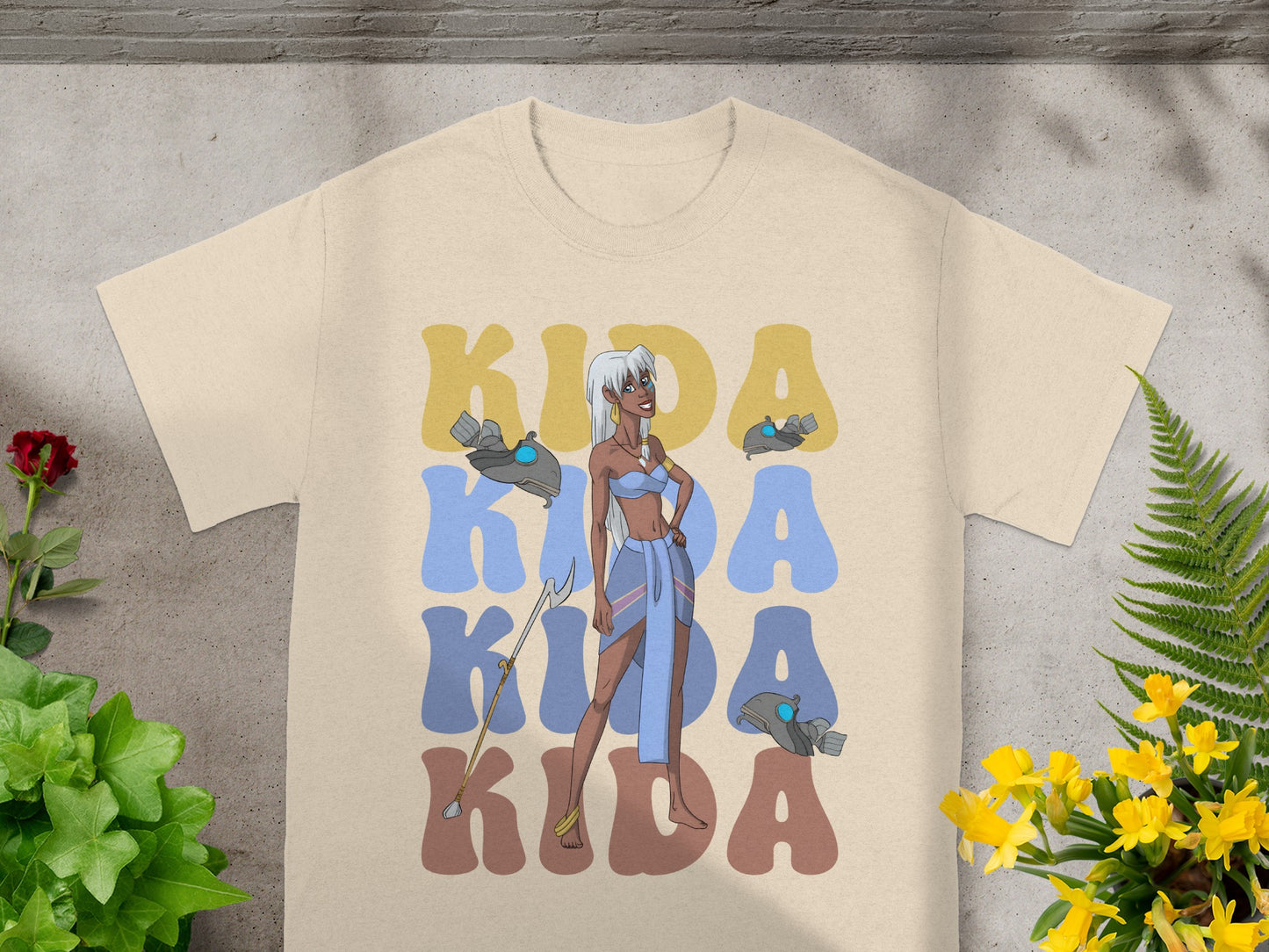 Kida illustration with "Kida Kida Kida" text on a tan t-shirt.