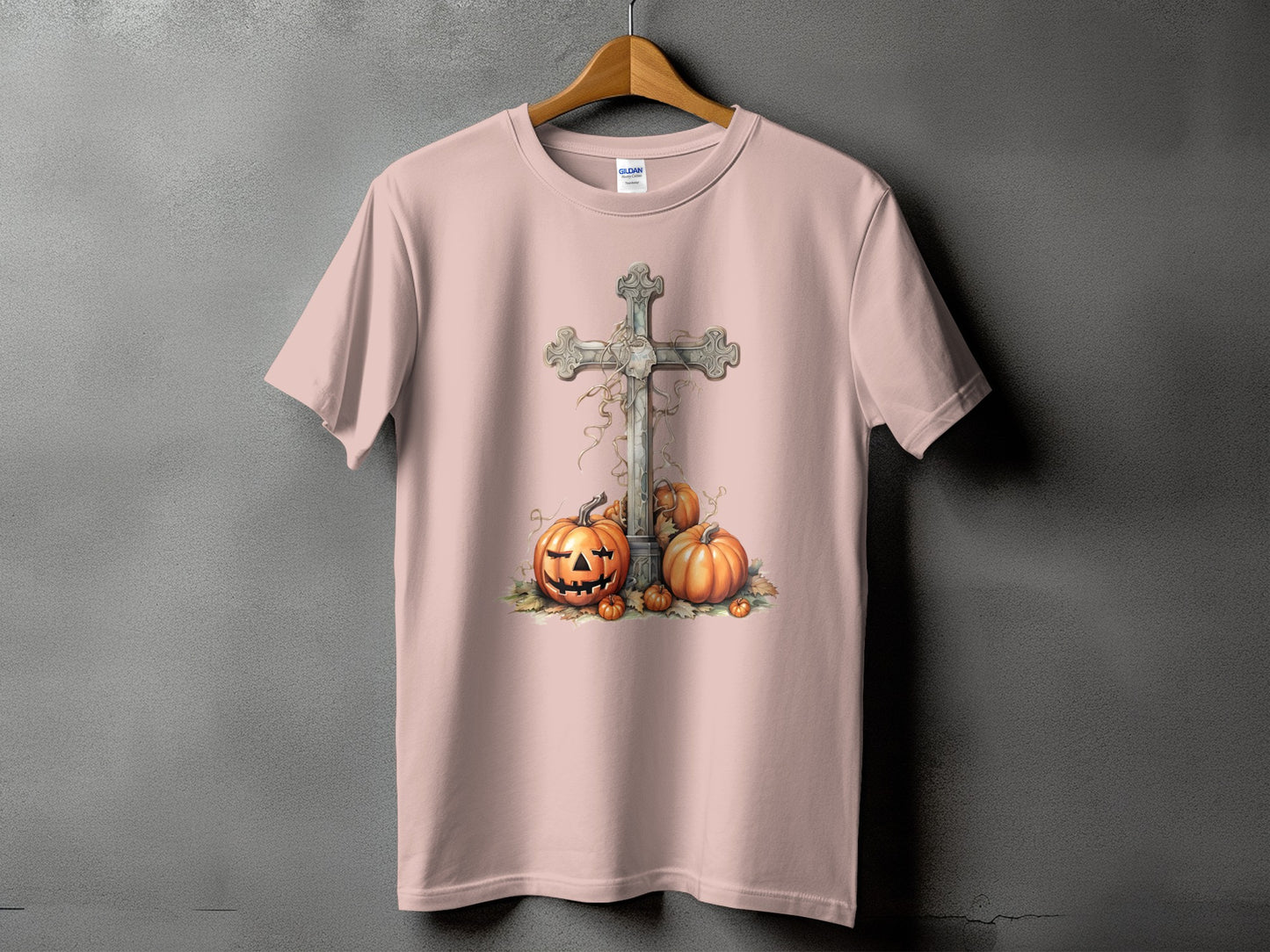 Pink t-shirt with a carved pumpkin and cross Halloween graphic design.