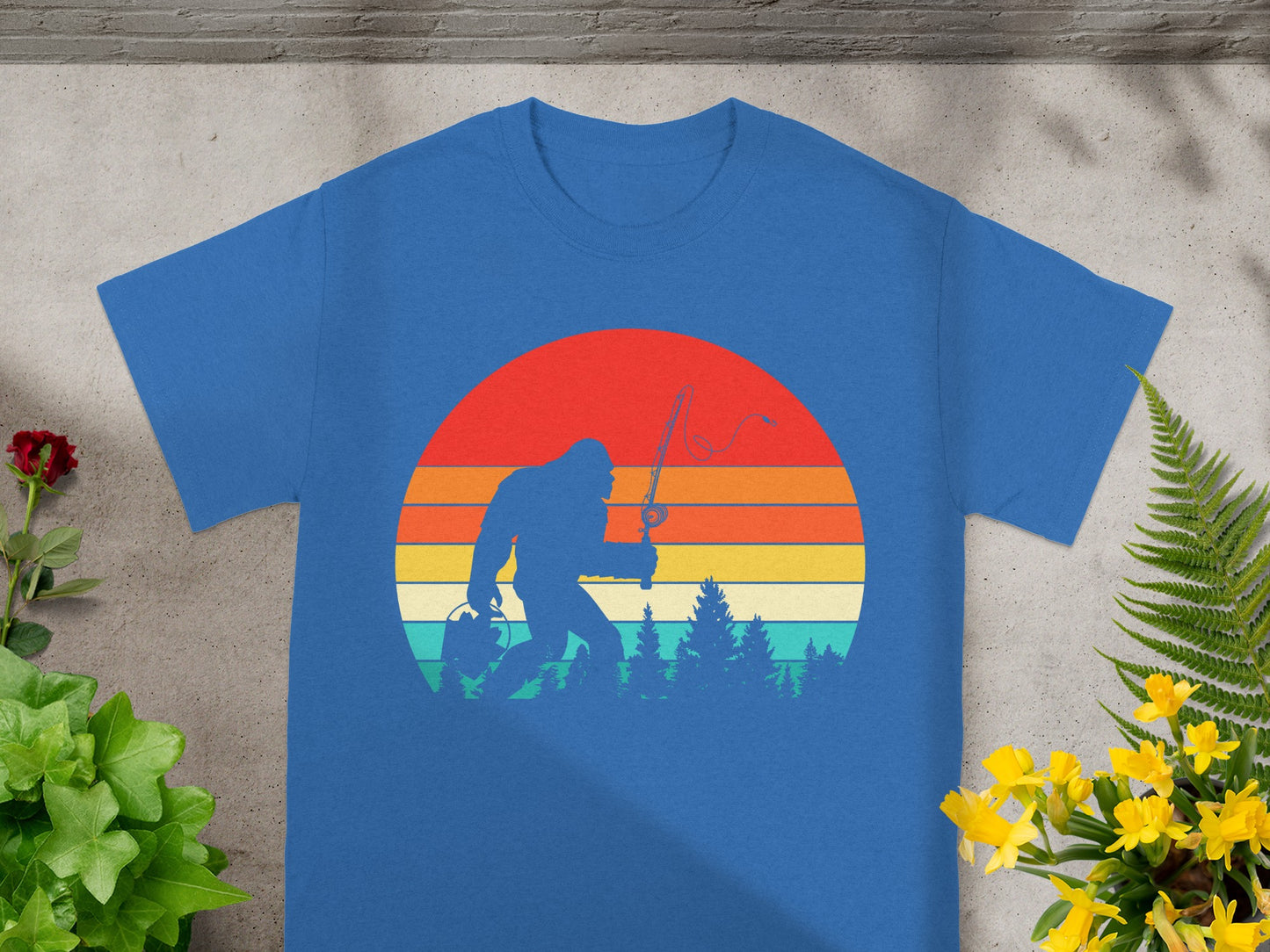 Bigfoot silhouette with fishing rod and bucket against a retro sunset and forest.