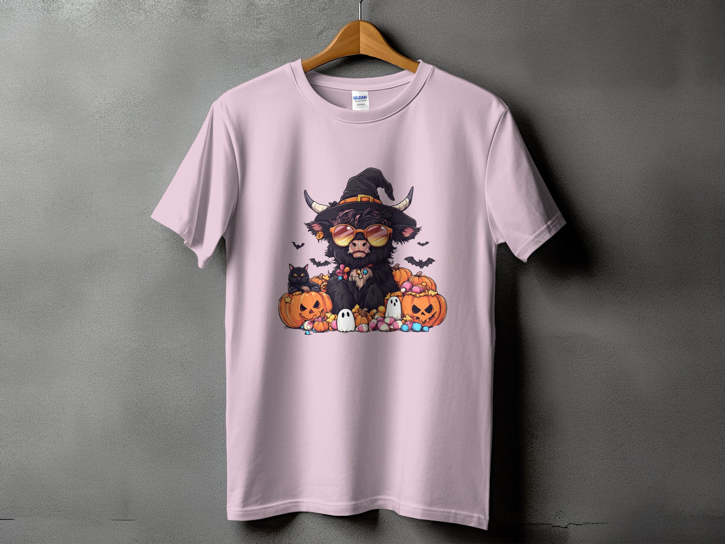Pink t-shirt with Halloween Highland cow graphic wearing witch hat and sunglasses.