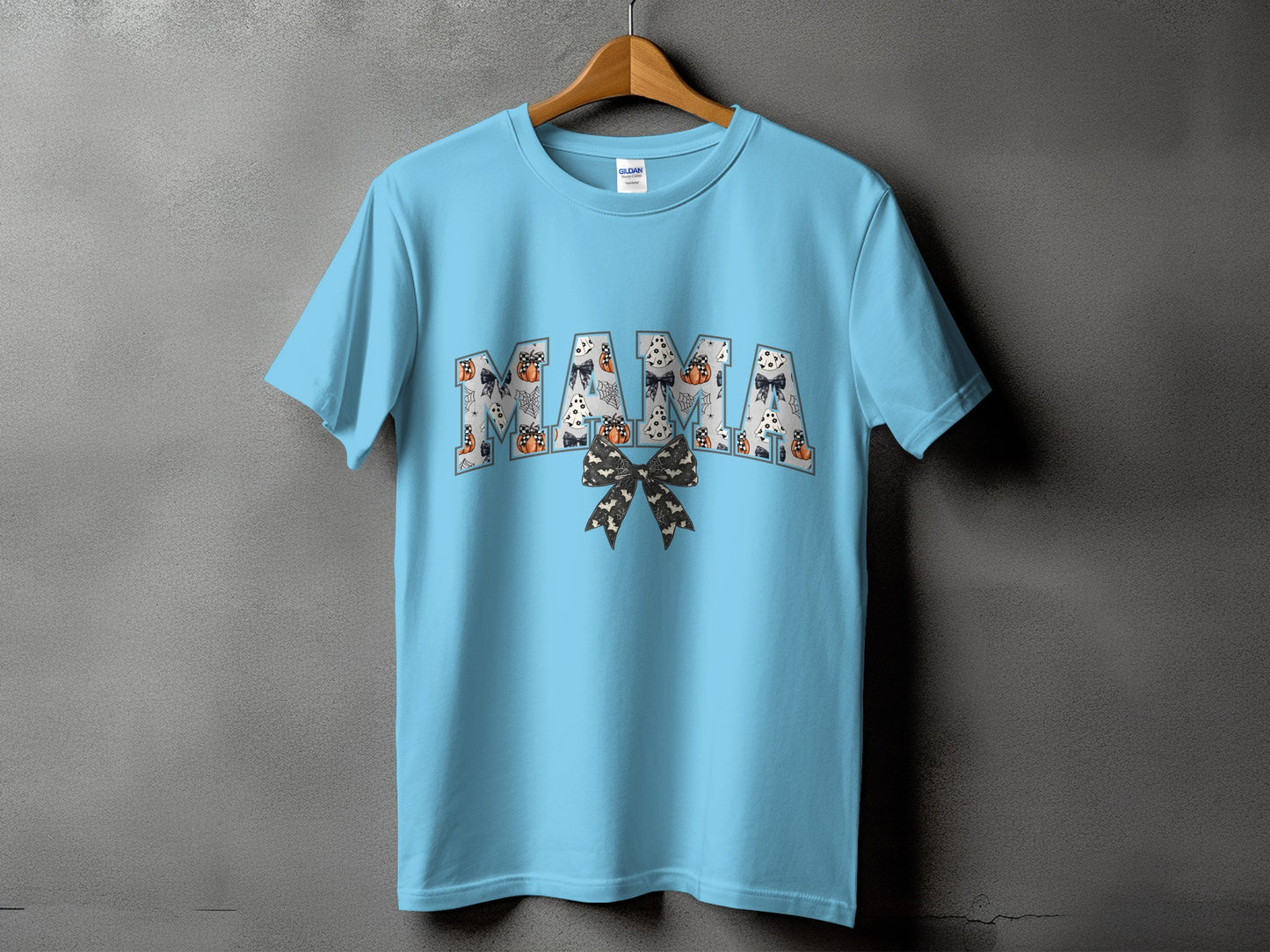 Light blue t-shirt with "MAMA" text in Halloween pattern.