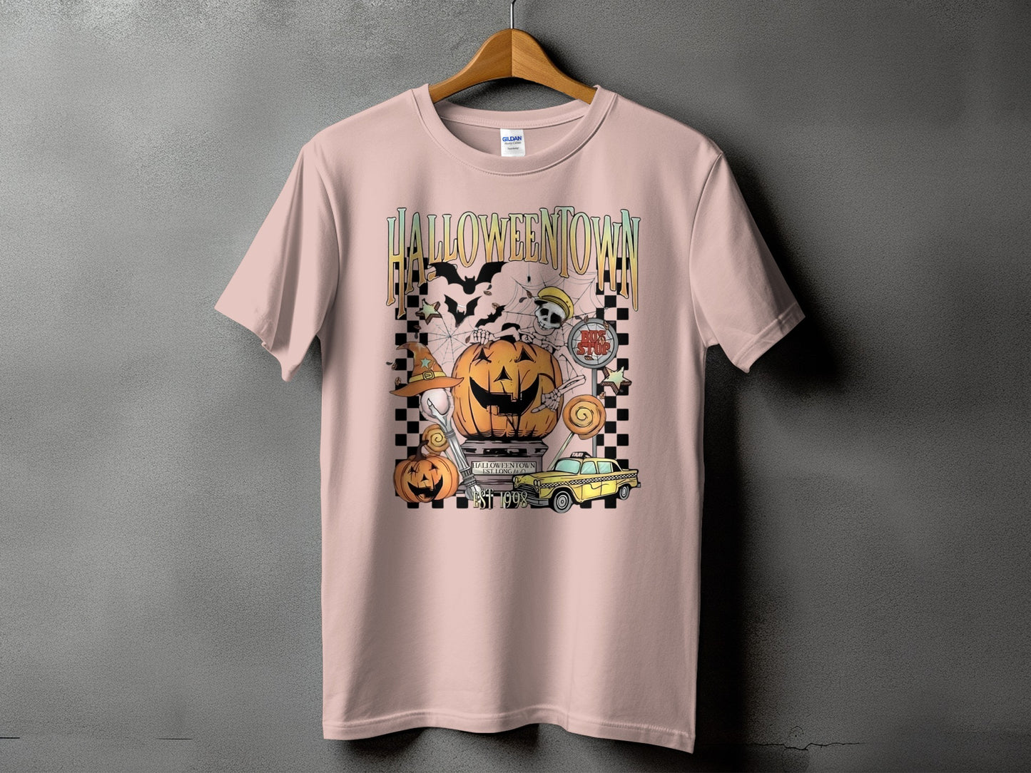Pink t-shirt with "Halloween Town" graphic featuring pumpkins, bats, and a yellow taxi.