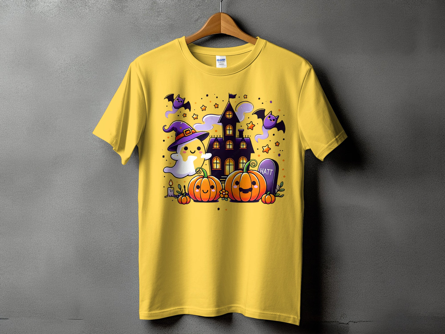 Yellow t-shirt with cute Halloween graphic featuring a ghost, pumpkins, bats, and a haunted house.