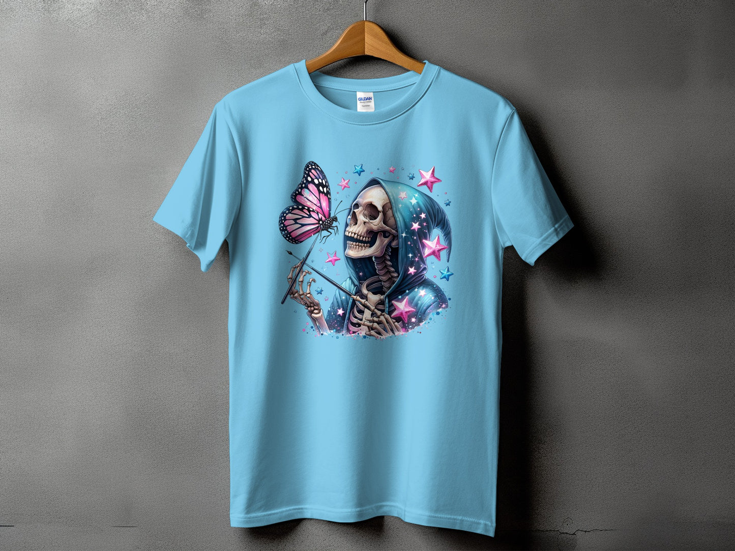 Light blue t-shirt with grim reaper skeleton, butterfly, and pink stars graphic.