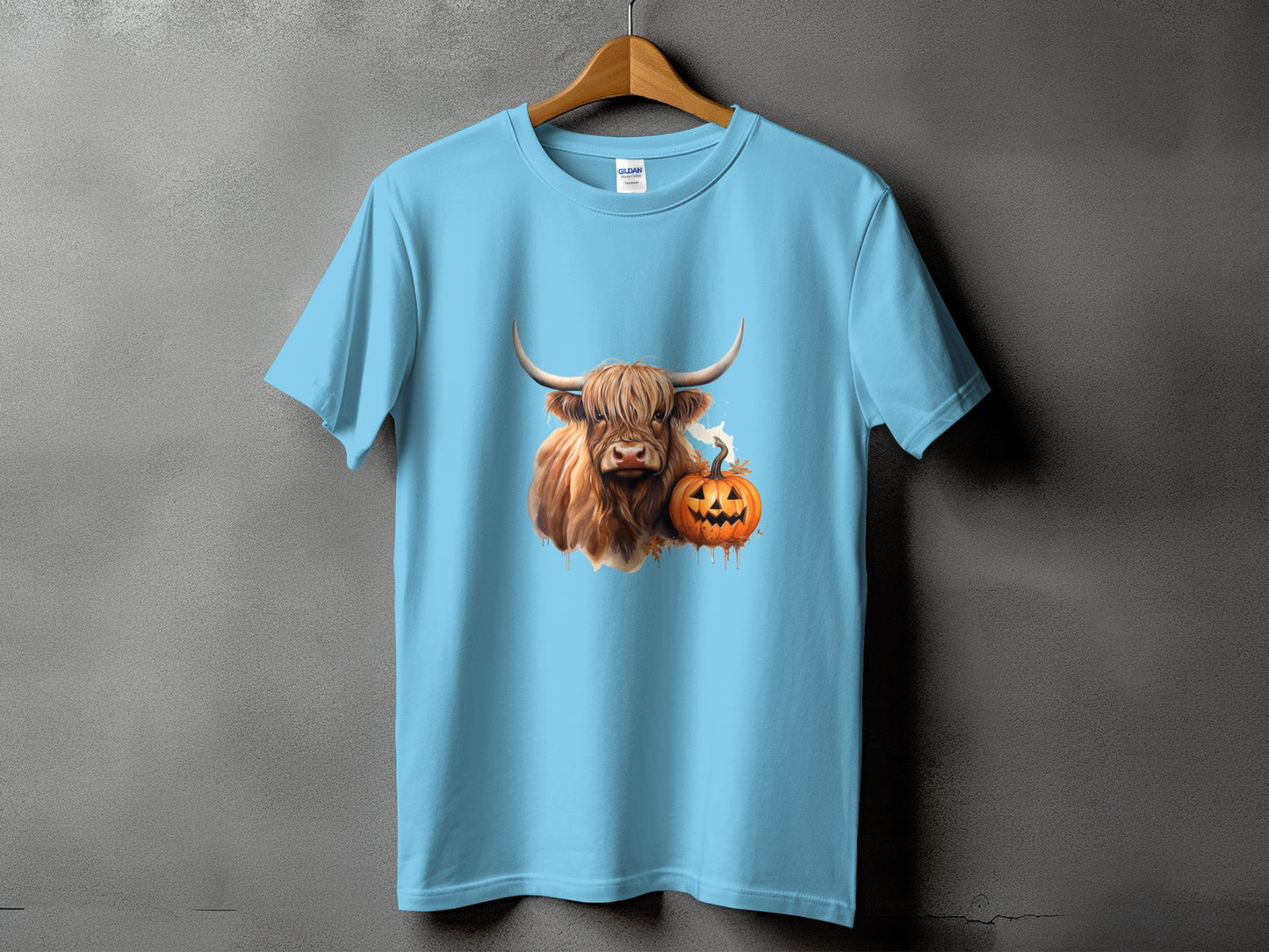 Light blue t-shirt with a Highland cow and pumpkin Halloween graphic.