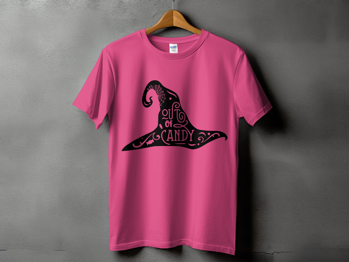 Pink t-shirt with black witch hat graphic saying "out of candy".