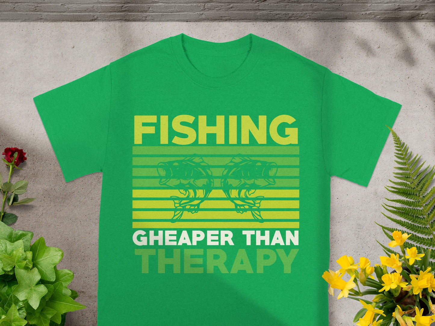 Green t-shirt with text "FISHING CHEAPER THAN THERAPY" and graphic of two fish.