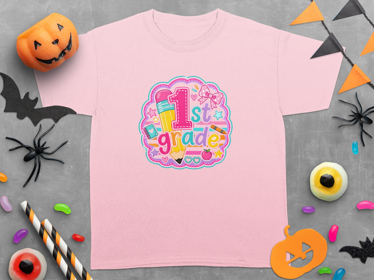 Pink t-shirt with "1st grade" graphic featuring a pencil and school supplies.