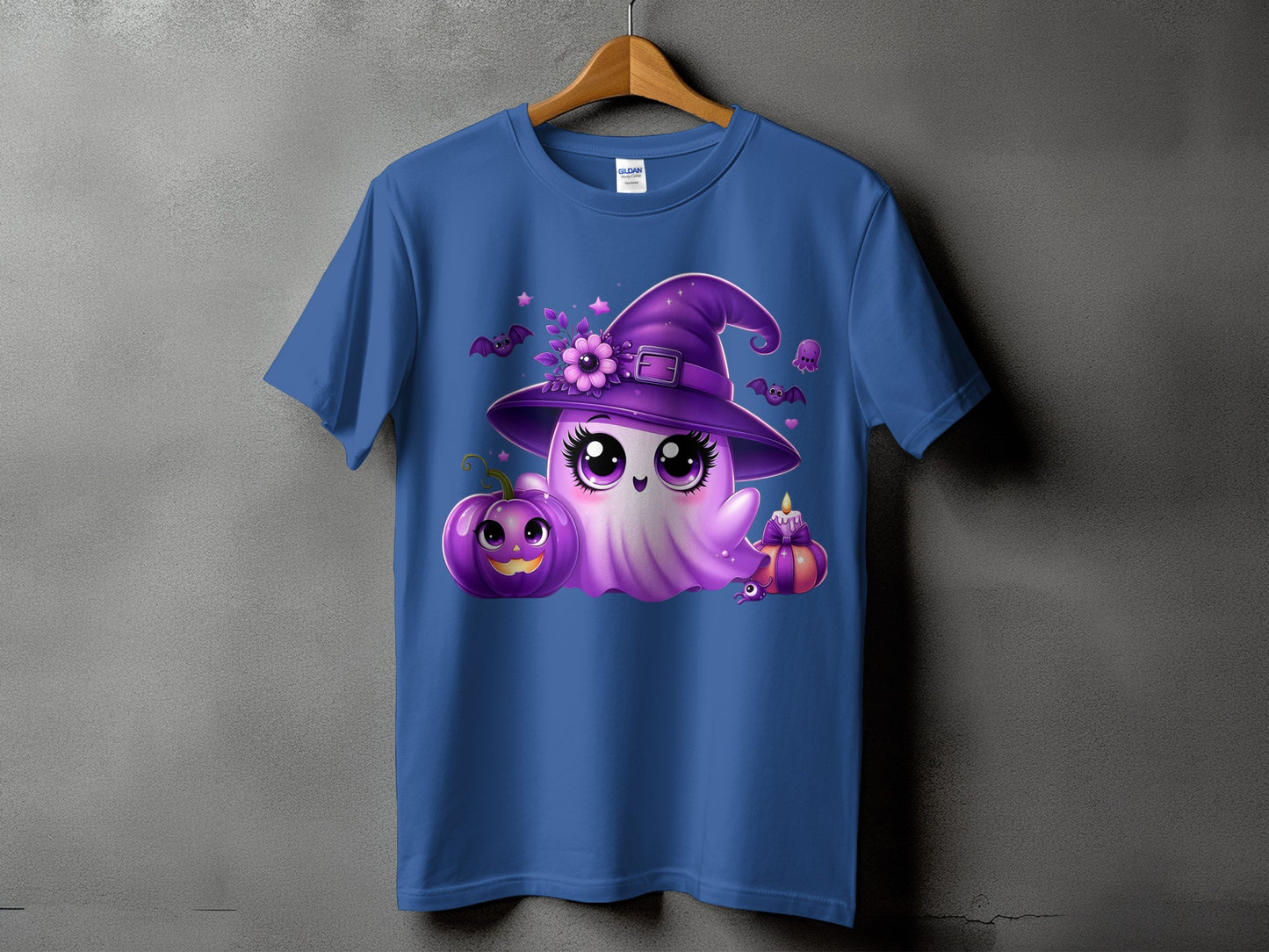 Purple ghost with witch hat, pumpkin, and candle graphic on a blue t-shirt.