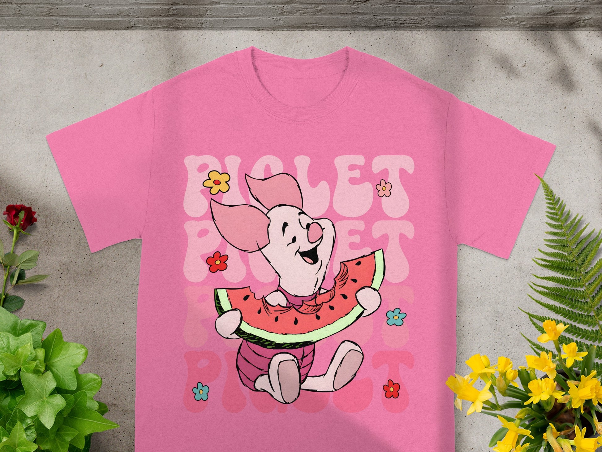Pink t-shirt with Piglet character eating watermelon and colorful flowers.