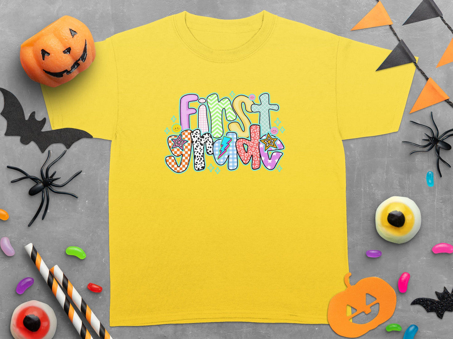 Yellow t-shirt with "First Grade" text and Halloween decorations.