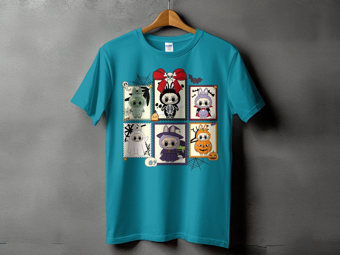 Teal t-shirt with Halloween-themed stamp-like illustrations of cute creatures.
