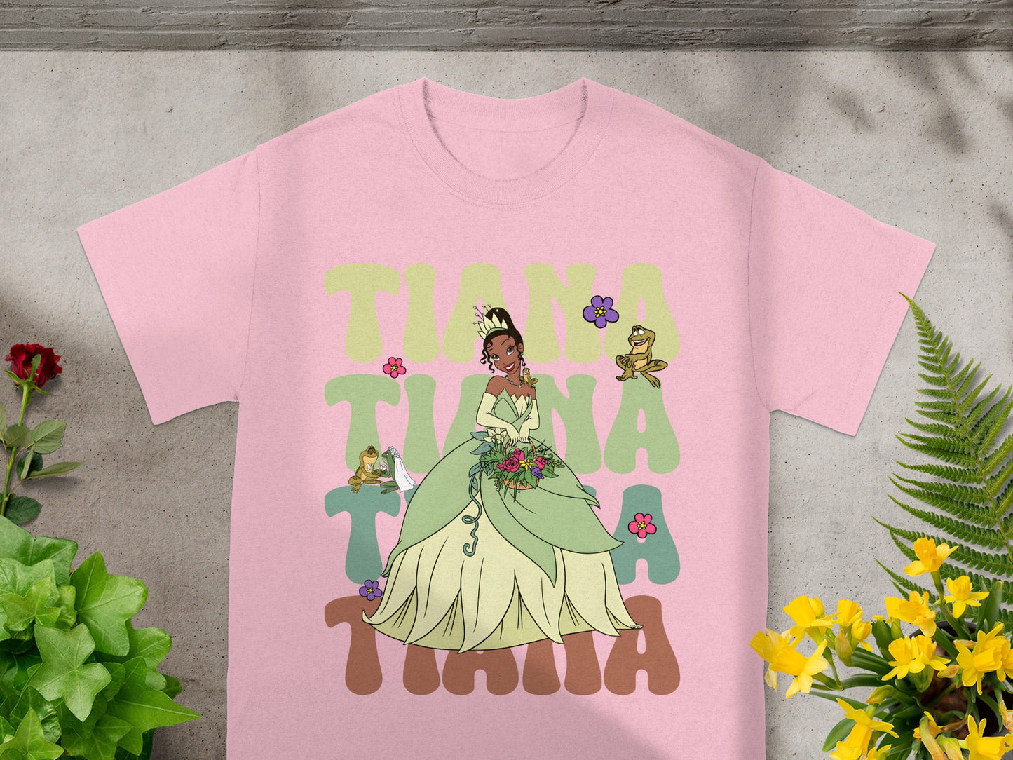 Pink t-shirt with Tiana and frog graphics in colorful lettering.