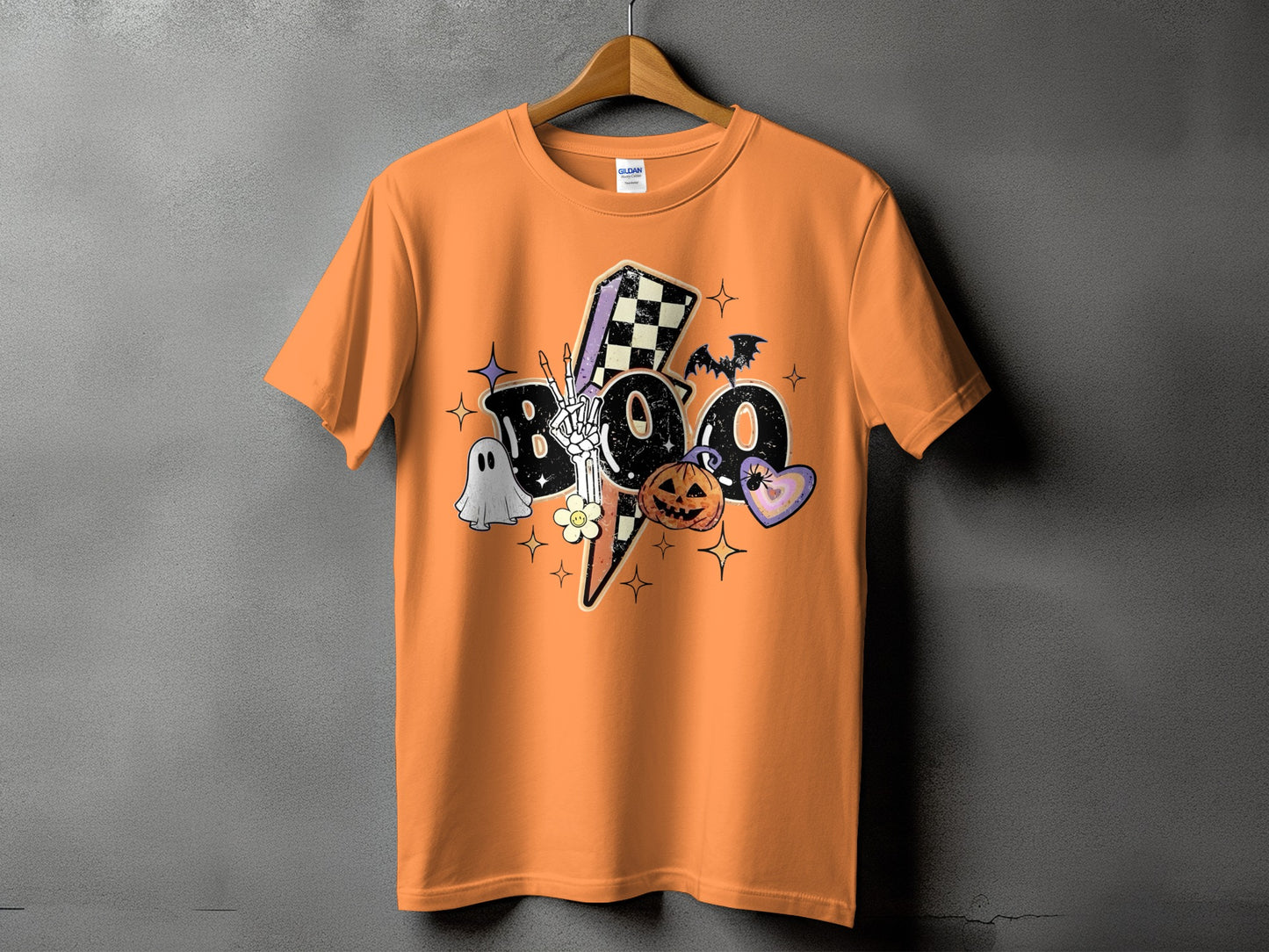 Orange t-shirt with a Halloween-themed "BOO" graphic featuring a ghost, pumpkin, and skeleton hand.