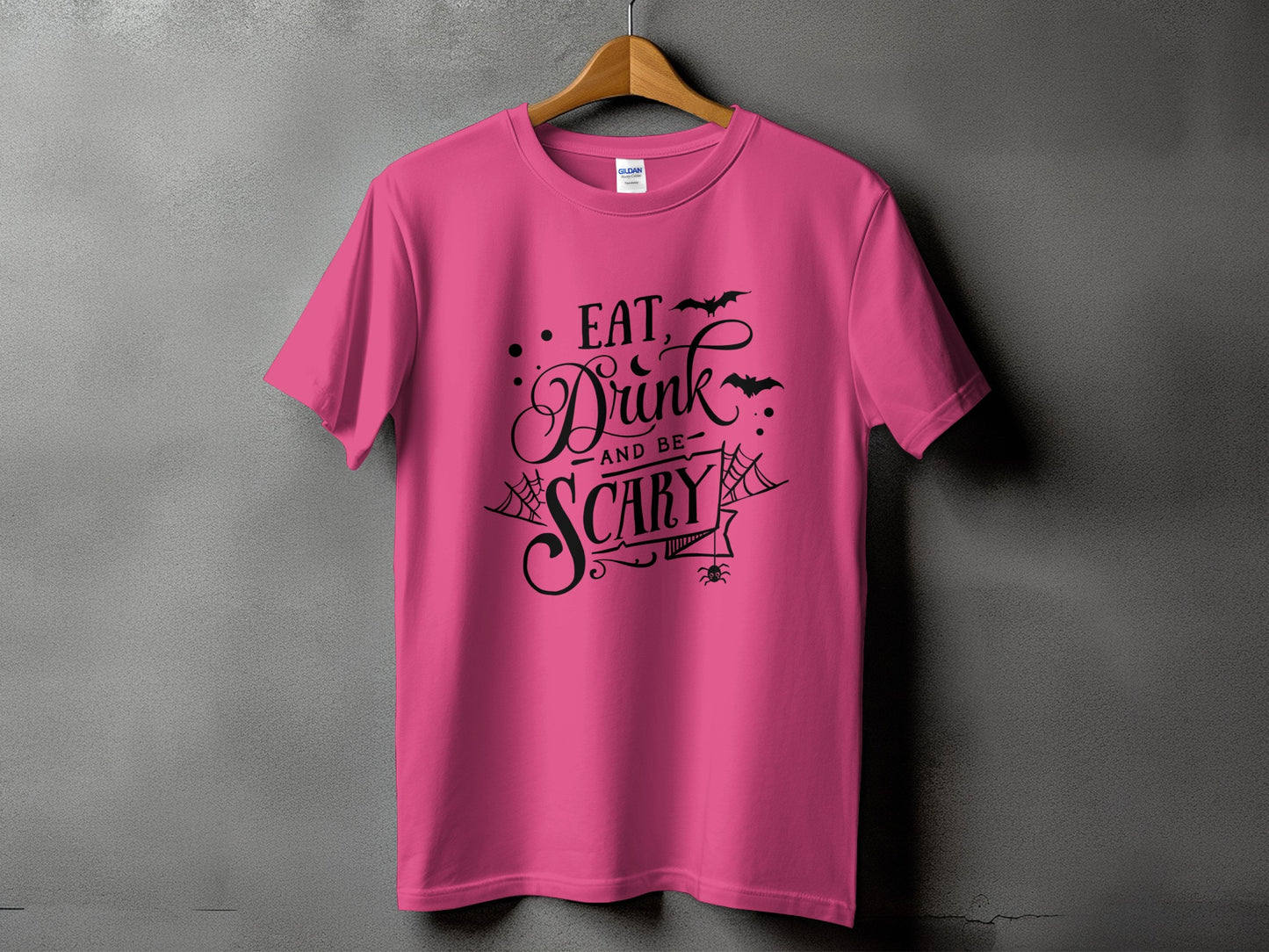 Pink t-shirt with black text: "Eat, Drink and be Scary" and Halloween graphics.