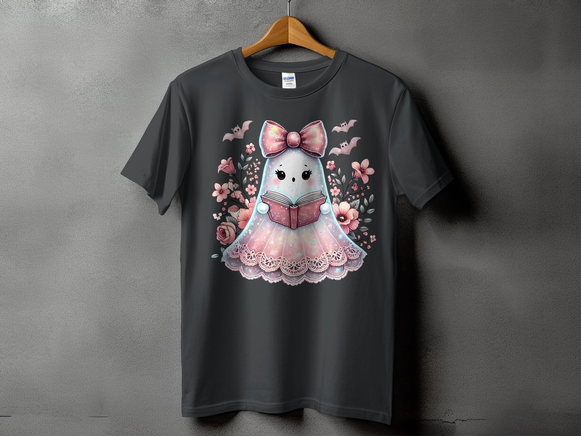 Gray t-shirt with a cute ghost reading a book, surrounded by flowers and bats.