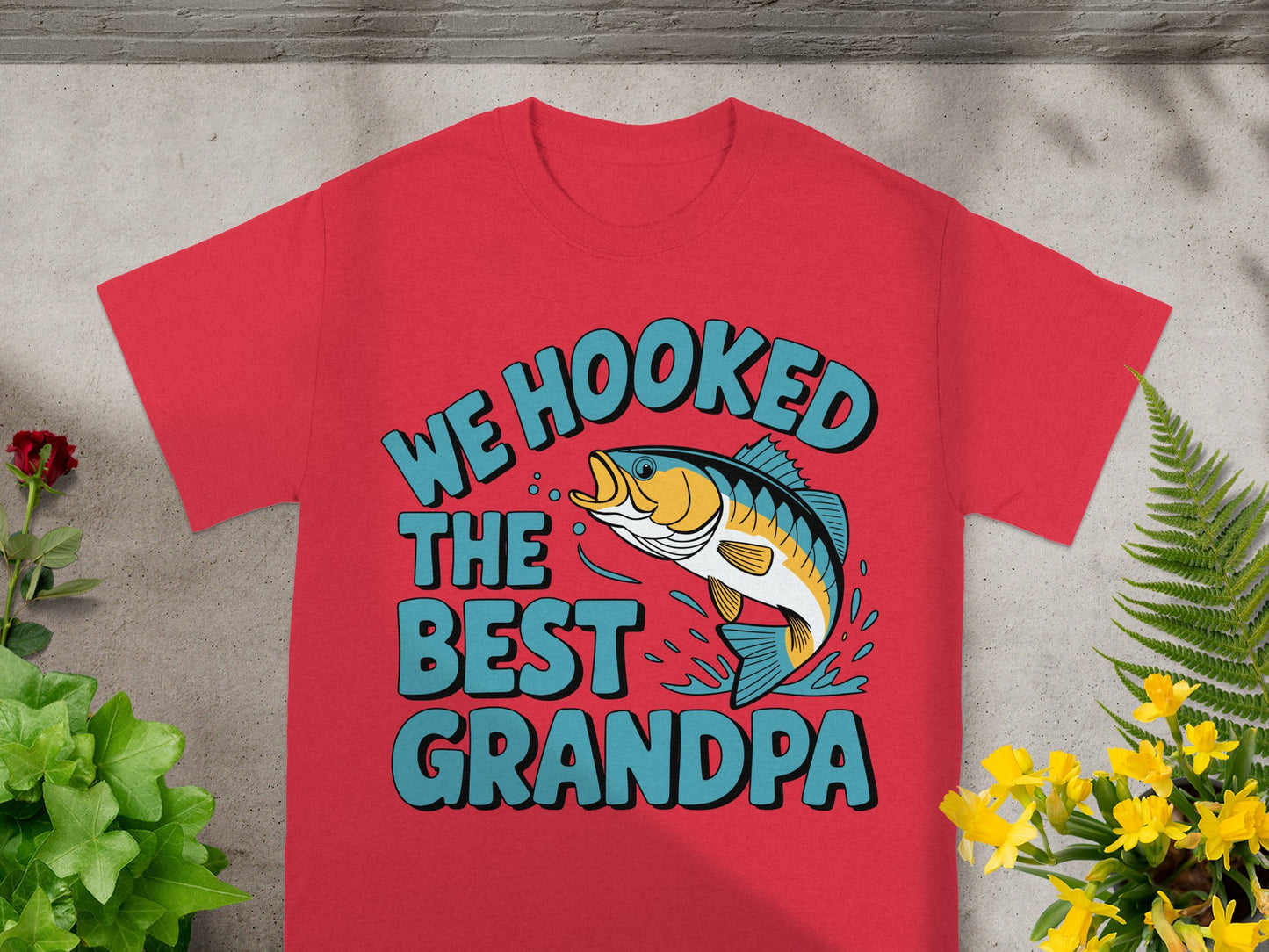 Red t-shirt with text "WE HOOKED THE BEST GRANDPA" and a jumping fish.