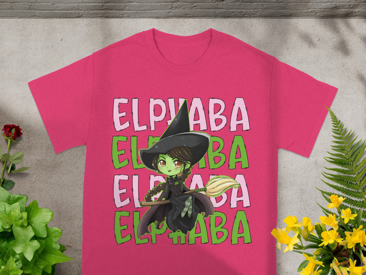 Pink t-shirt with Elphaba the witch graphic and green text.