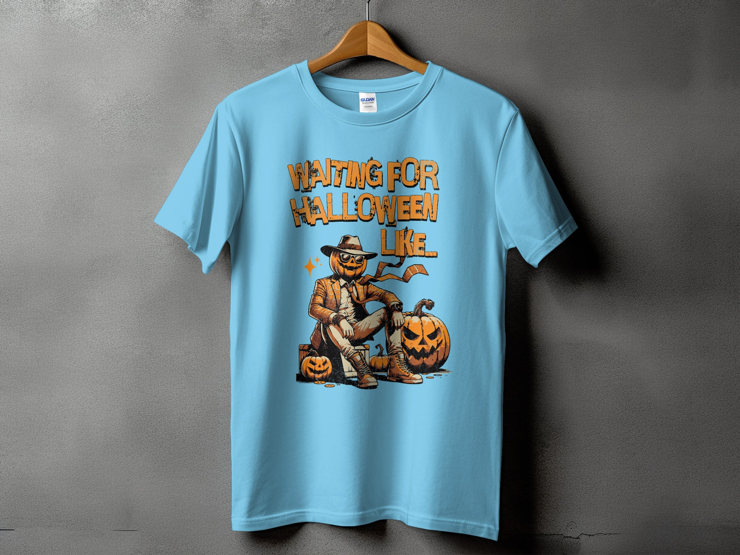 Light blue t-shirt with "Waiting for Halloween Like" graphic featuring a scarecrow-like pumpkin character.