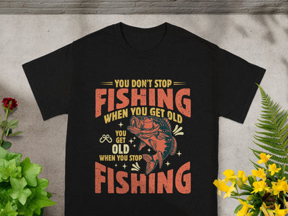Black t-shirt with "You Don't Stop Fishing When You Get Old" text and fish graphic.