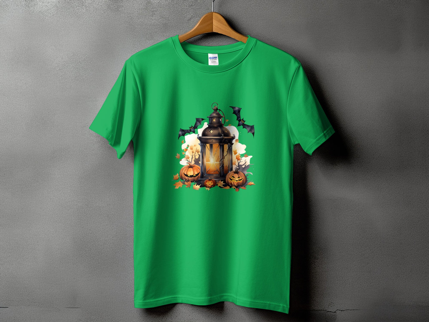 Green t-shirt with Halloween graphic of lantern, pumpkins, bats, and autumn leaves.
