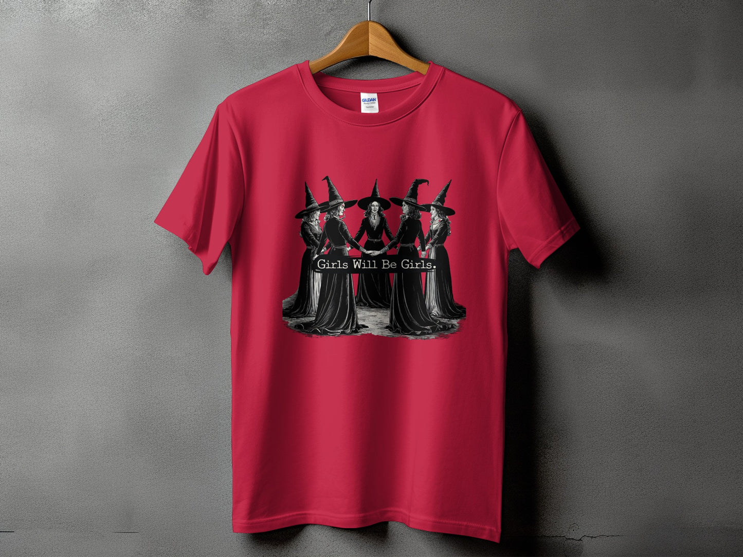 Red t-shirt with a graphic of five witches holding hands and text "Girls Will Be Girls."