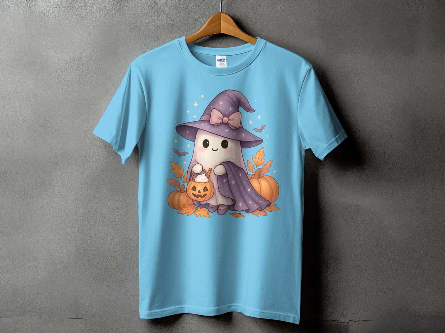 Light blue t-shirt with a cute ghost in a witch hat, holding a pumpkin bucket.