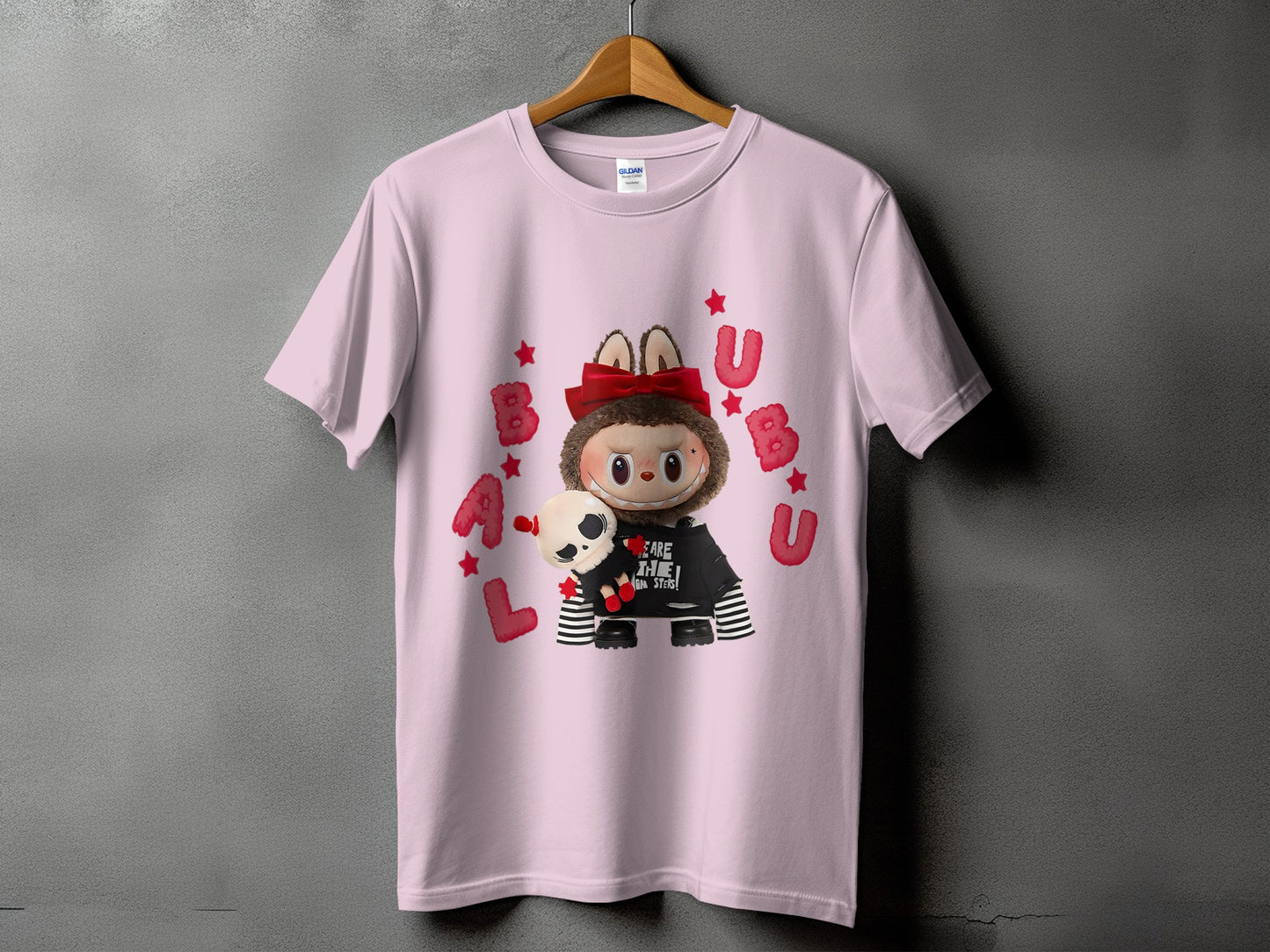 Pink t-shirt with cartoon character holding a skull, surrounded by red letters and stars.