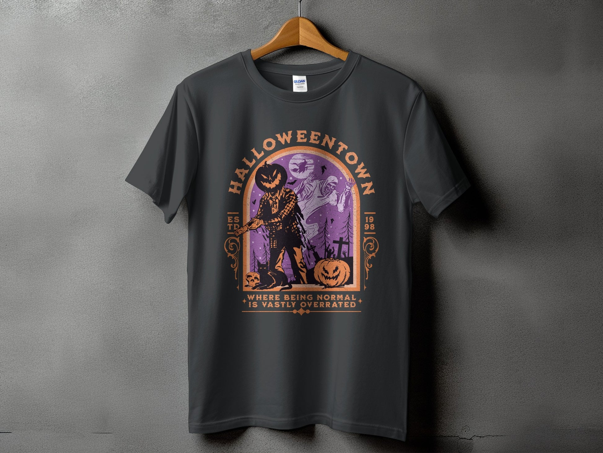 Dark grey t-shirt with a Halloween graphic and the text "HALLOWEENTOWN WHERE BEING NORMAL IS VASTLY OVERRATED".