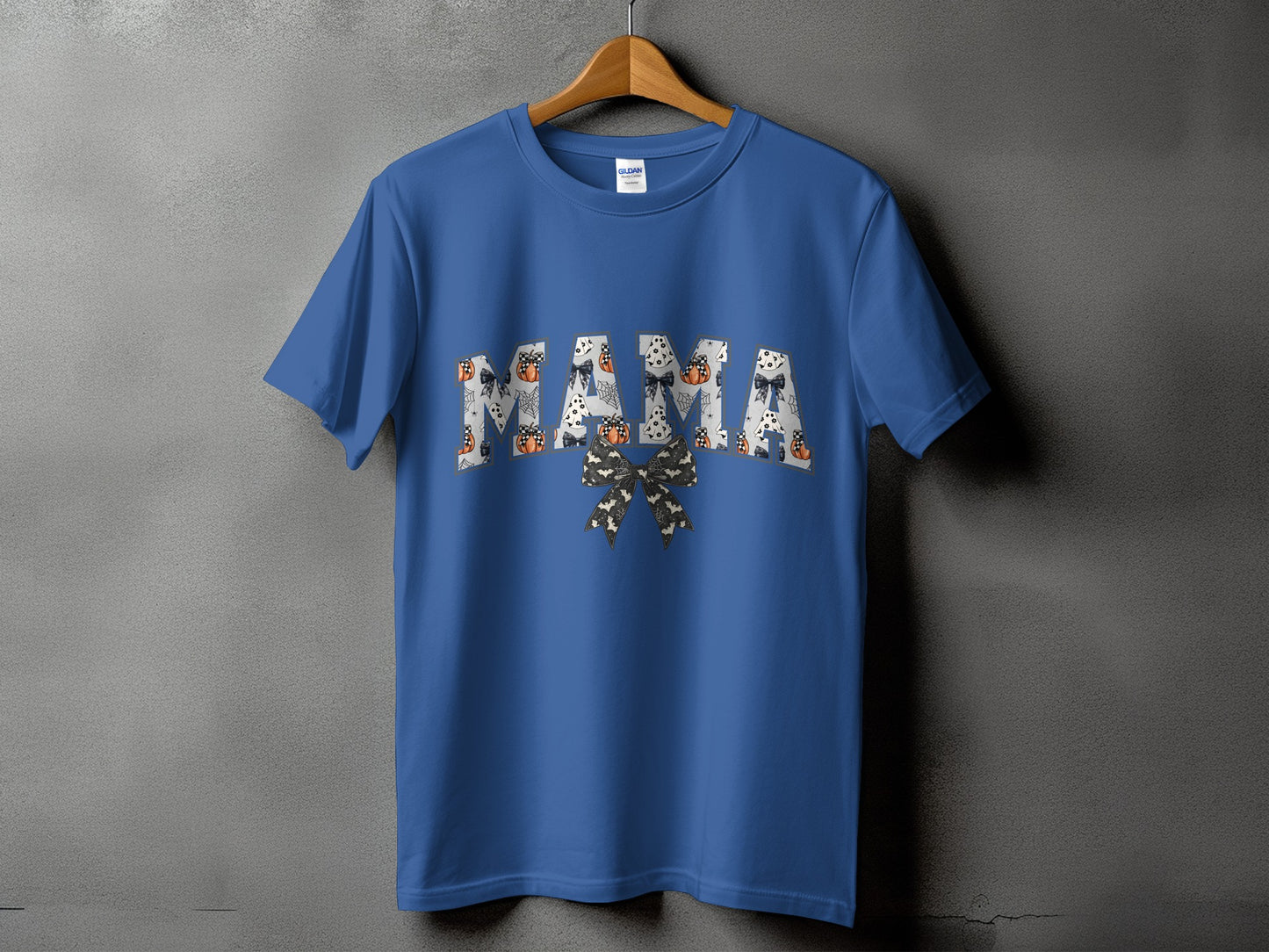 Blue t-shirt with "MAMA" text in Halloween patterns and a bow.