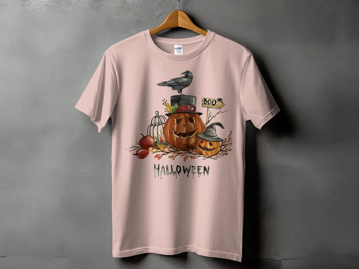 Pink t-shirt with Halloween graphic featuring pumpkins, a crow, and the word HALLOWEEN.