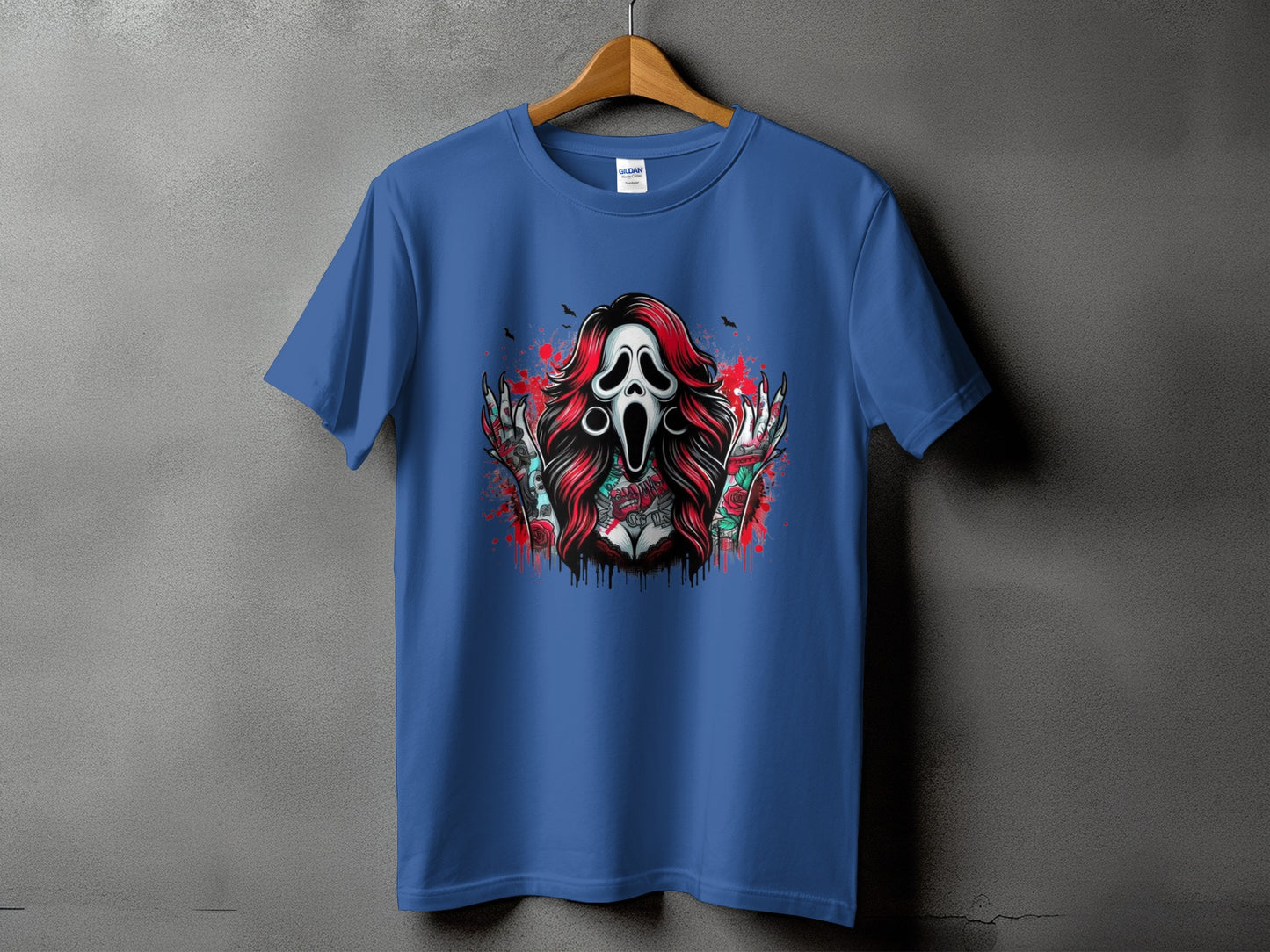 Blue t-shirt with a horror-themed graphic featuring a screaming mask, red hair, and tattooed arms.
