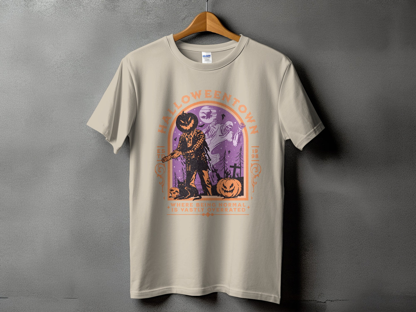 Light tan t-shirt with a graphic of a jack-o'-lantern man and ghosts in a spooky scene.