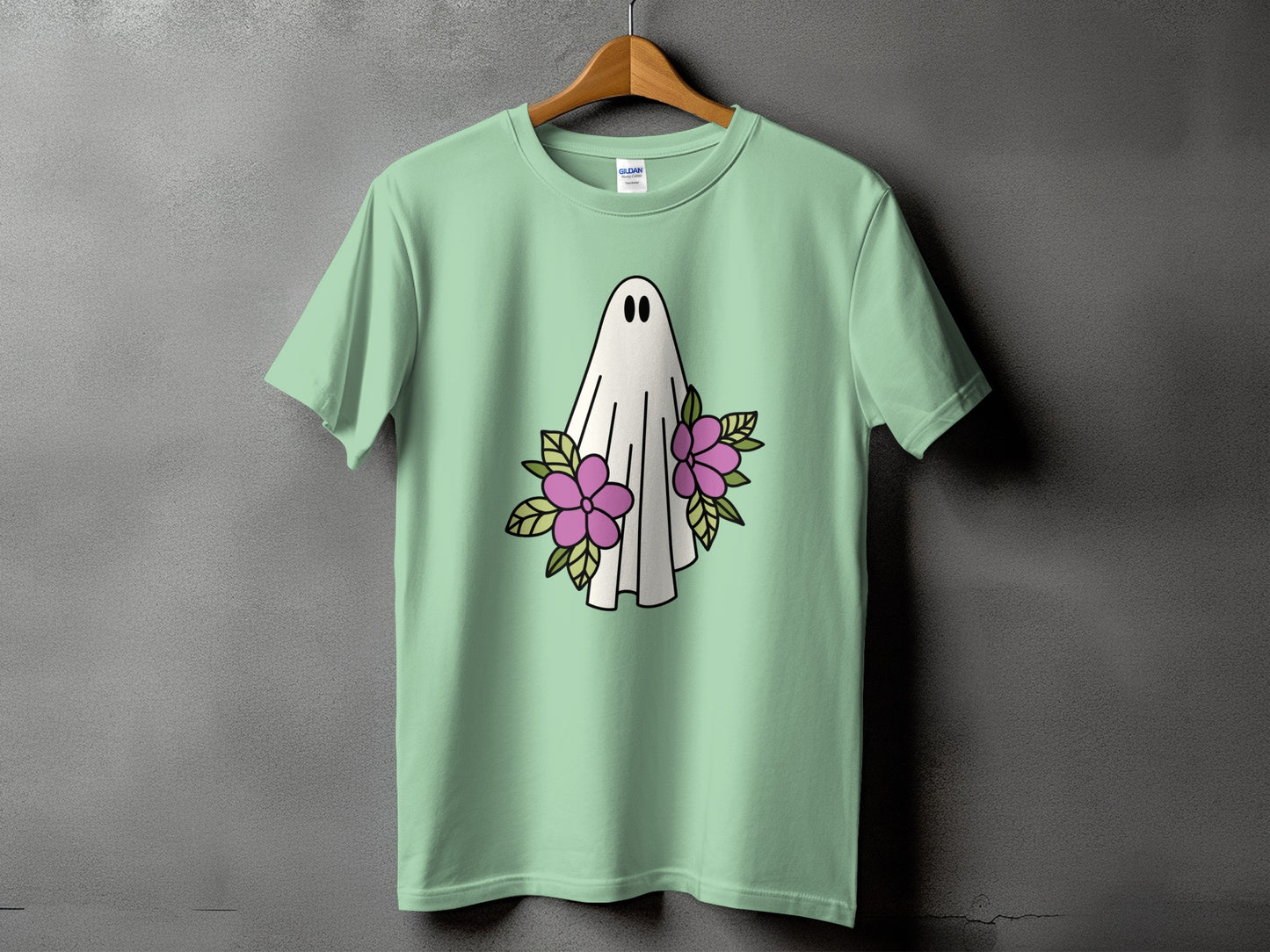 Light green t-shirt with a white ghost and pink flowers graphic.