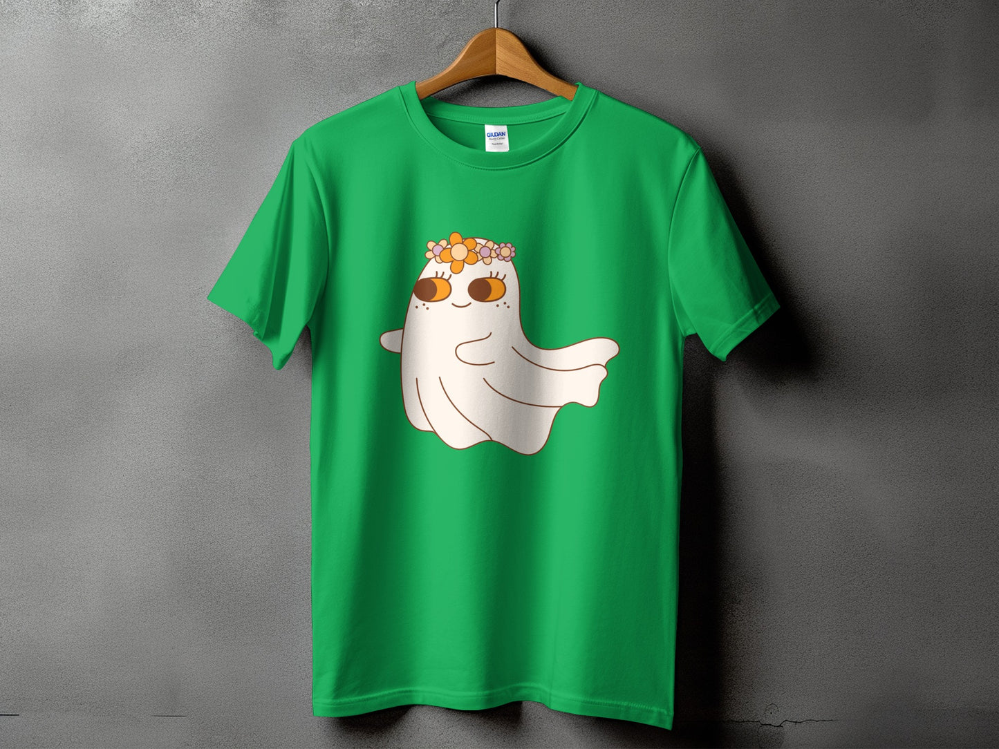 Green t-shirt with a cartoon ghost wearing a flower crown and large orange eyes.