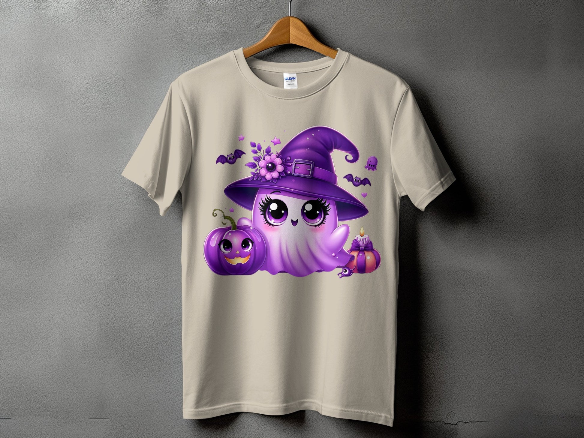 Ghost with witch hat and Halloween decorations on a tan t-shirt.