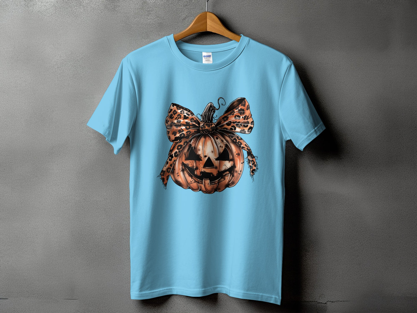 Light blue Gildan t-shirt with a jack-o'-lantern graphic and leopard print bow.