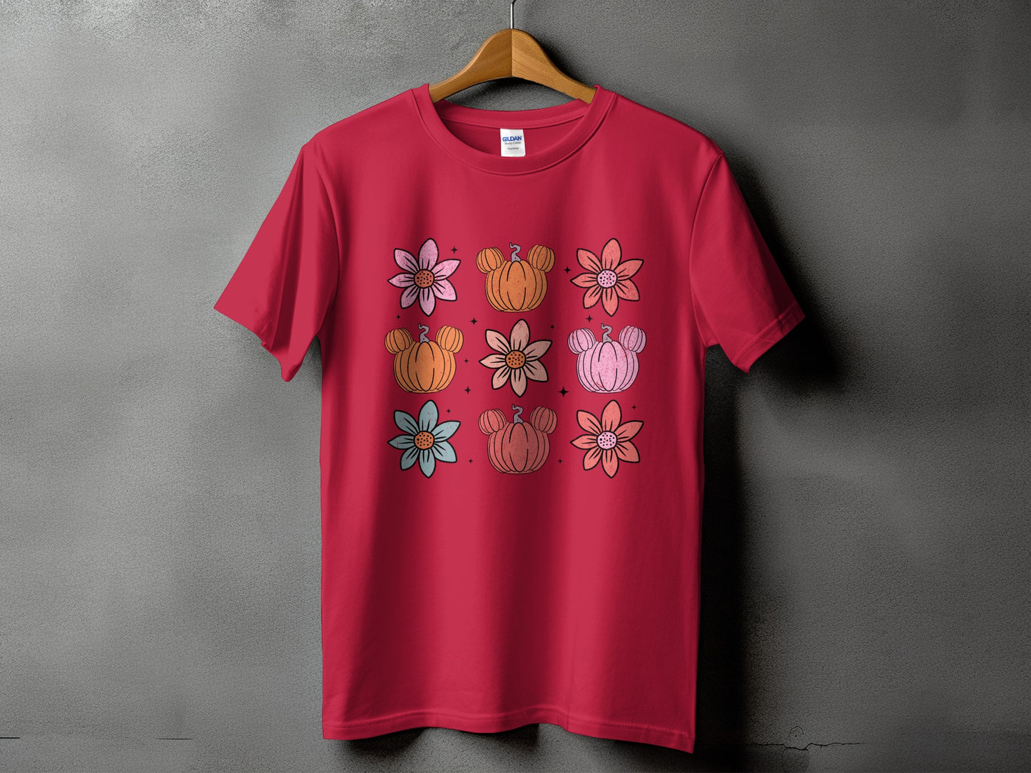 Red t-shirt with a grid of cartoon flowers and pumpkins with mouse ears.