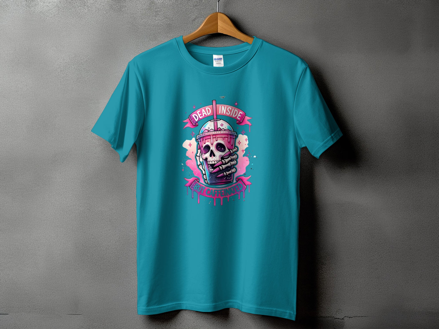 Teal t-shirt with a graphic of a skeleton holding a pink drink with "DEAD INSIDE" and "BUT CAFFEINATED".