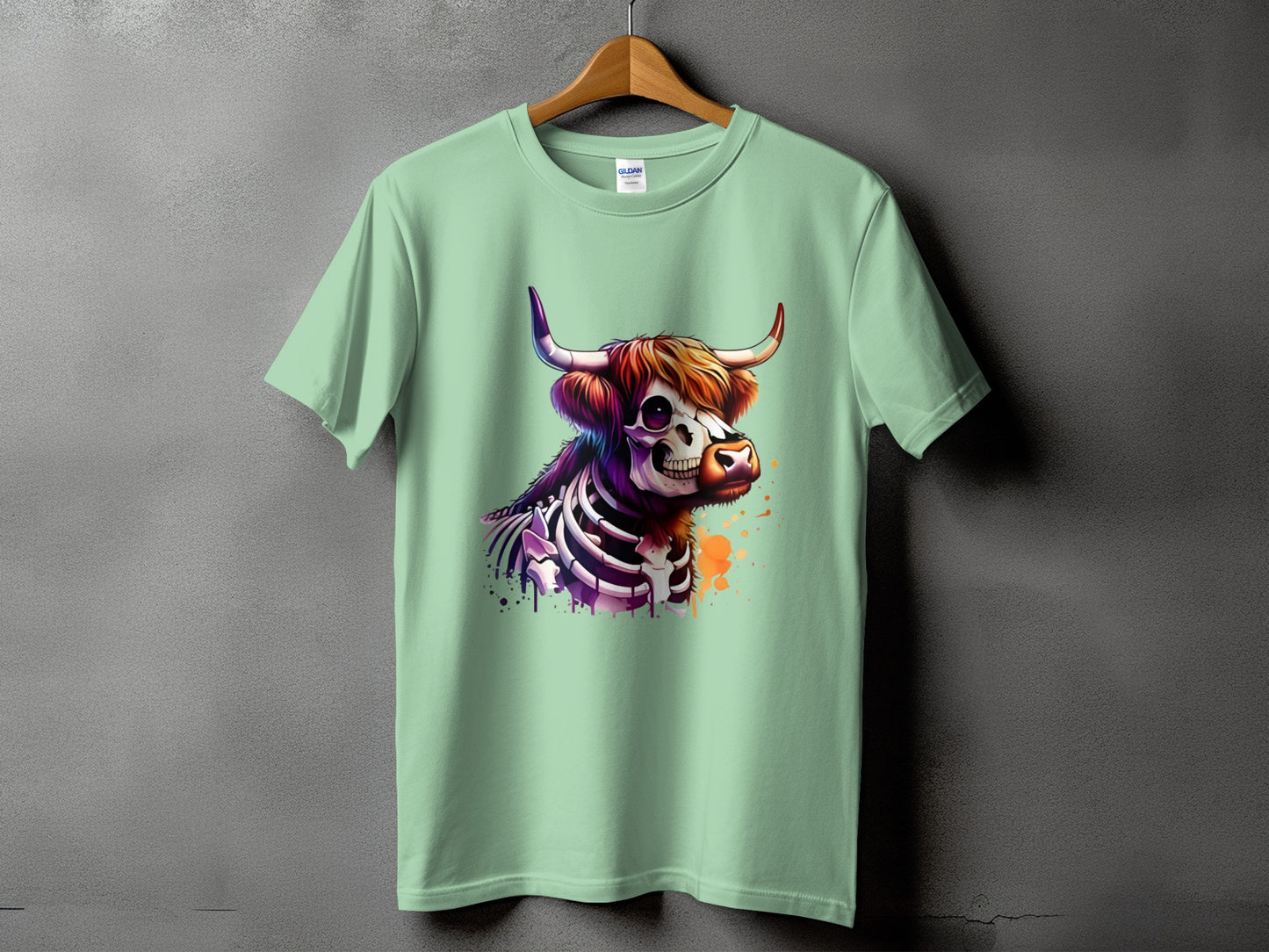 Mint green t-shirt with a colorful skeleton cow graphic and paint splatters.