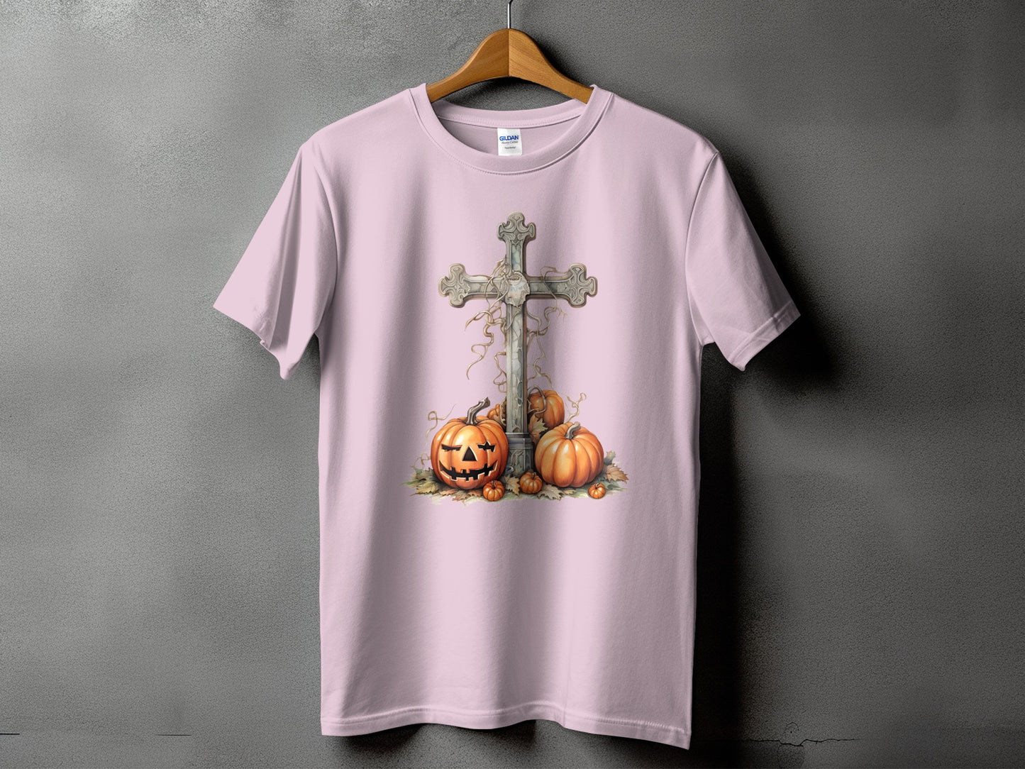 Pink t-shirt with a distressed cross and jack-o'-lanterns graphic design.