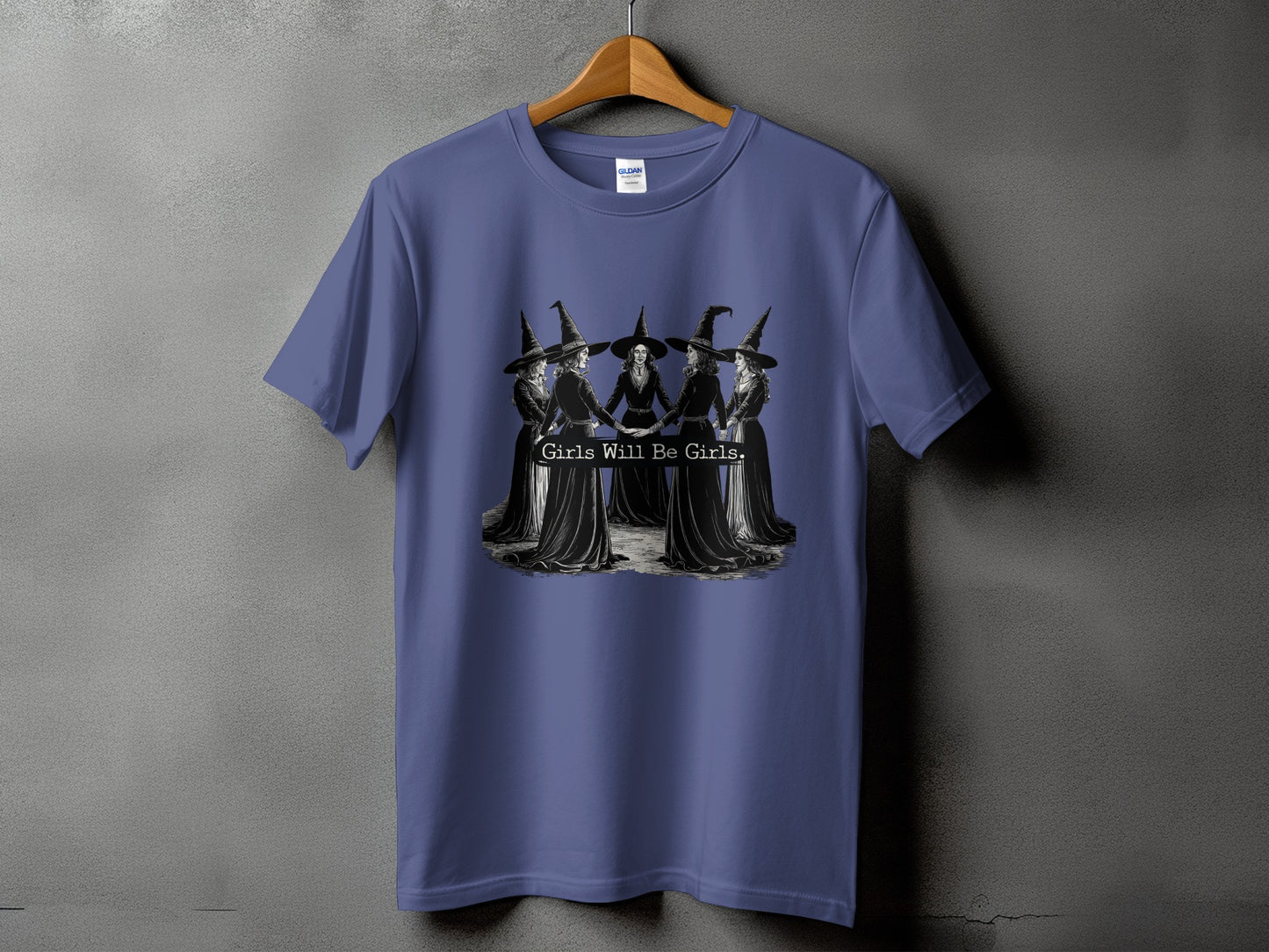 T-shirt with a graphic of five witches in a circle holding hands and the text "Girls Will Be Girls."