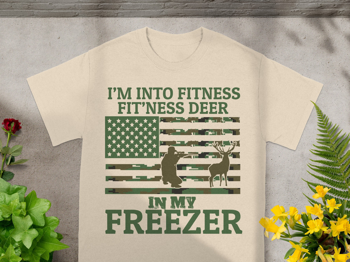 Tan t-shirt with text "I'm Into Fitness Fit'ness Deer In My Freezer" and flag graphic.