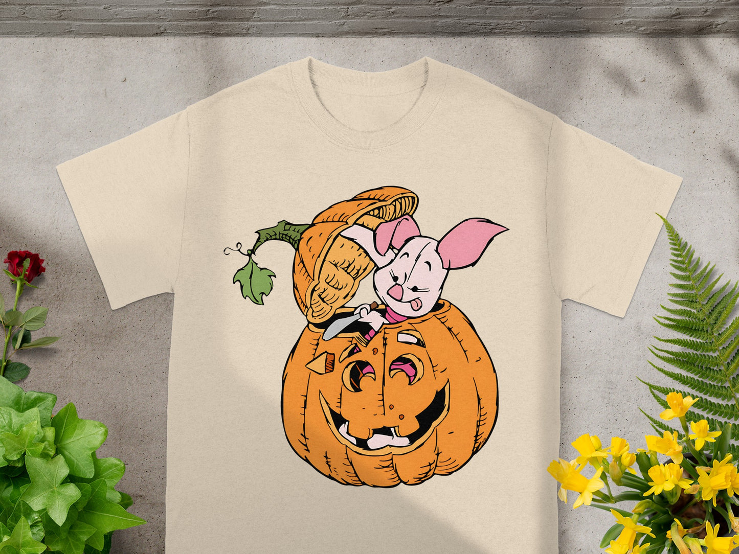 Piglet popping out of a carved Halloween pumpkin on a cream t-shirt.