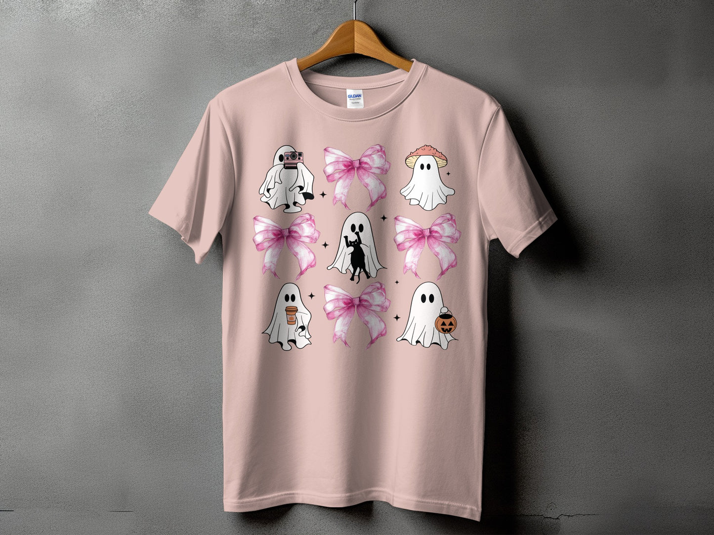 Pink t-shirt with ghosts, bows, a cat, and a pumpkin graphic.