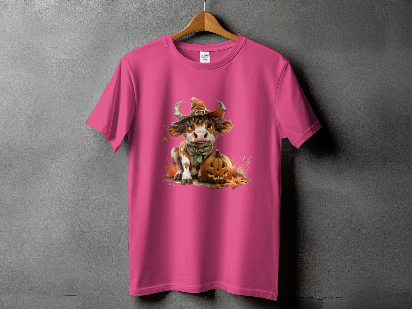 Pink t-shirt with a Halloween-themed illustration of a cow wearing a witch hat.