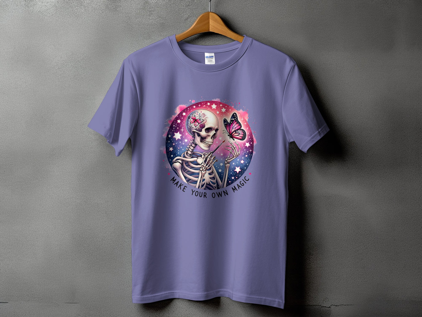 Purple t-shirt with a skeleton painting a butterfly, with text "Make Your Own Magic".