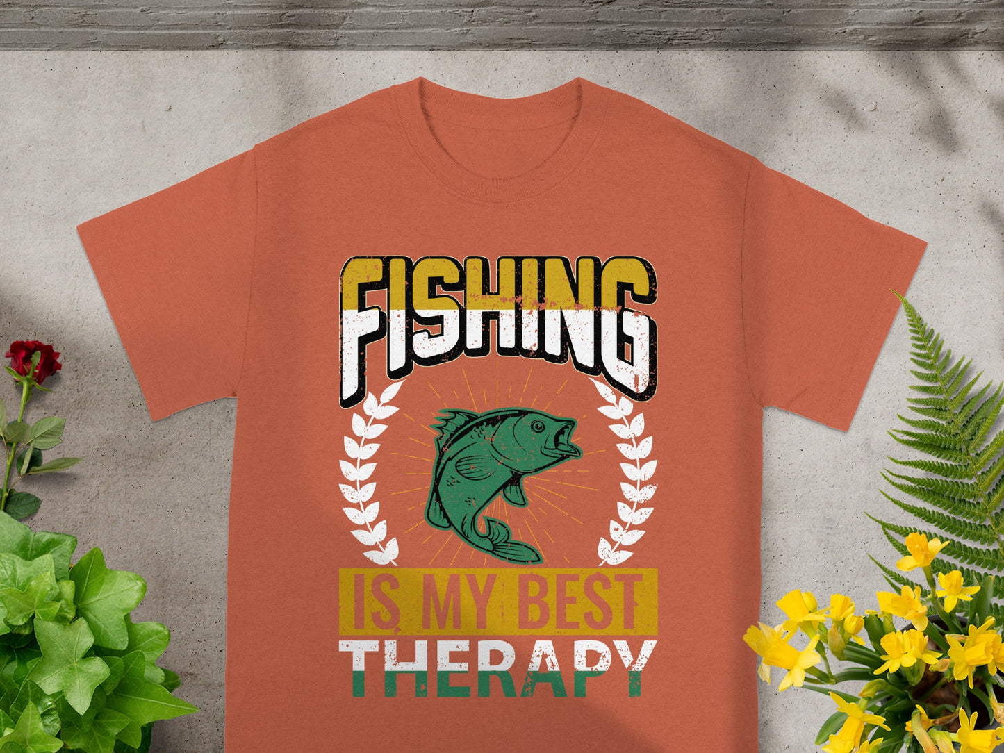 Orange t-shirt with "FISHING IS MY BEST THERAPY" text and a green fish graphic.